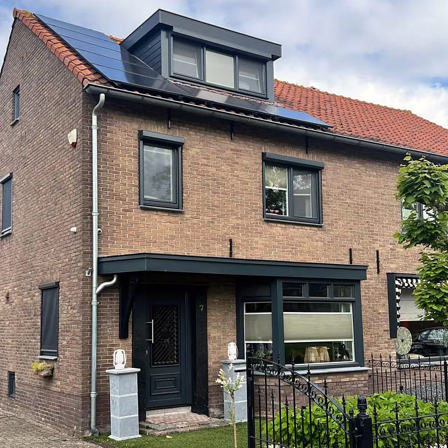Gerenoveerde Nederlandse hoekwoning met antraciet kozijnen, dakkapel en een bijpassende voordeur