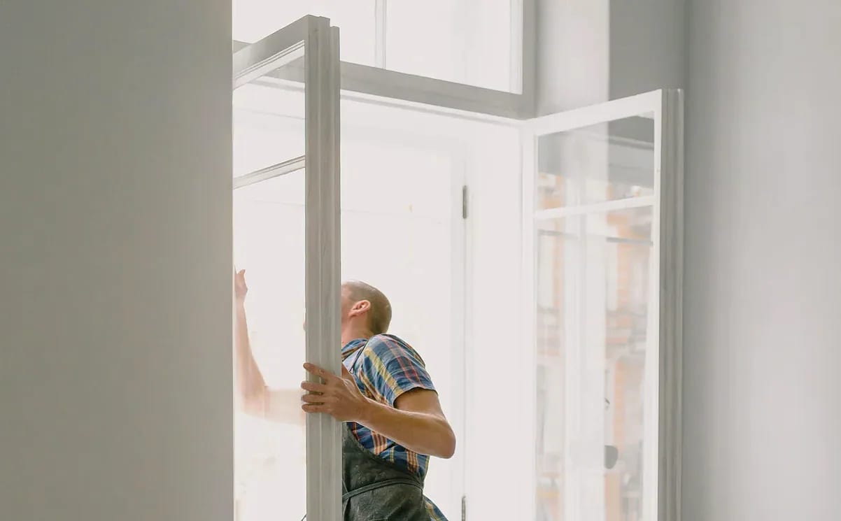 Open raamvleugel tijdens kozijnrenovatie, met zicht op een Nederlandse straat