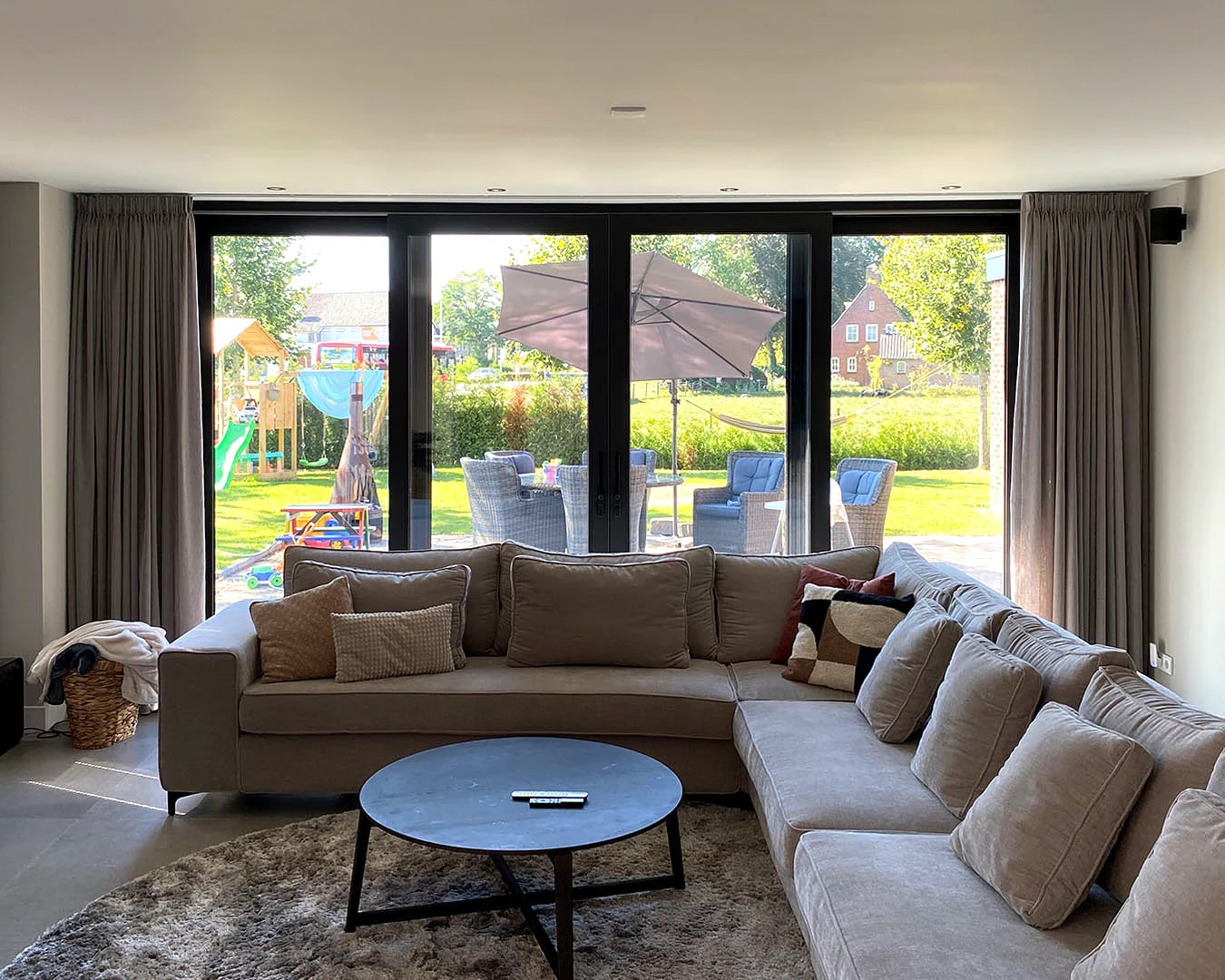 Vierdelige schuifpui vanuit de woonkamer naar tuin en terras van een Nederlandse woning
